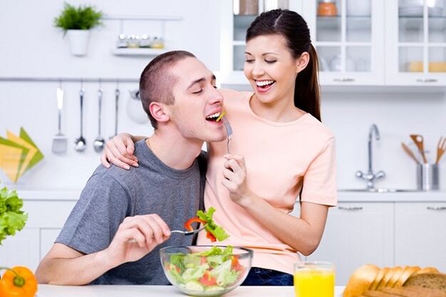 a menina alimenta o homem com salada de vitaminas para aumentar a potência